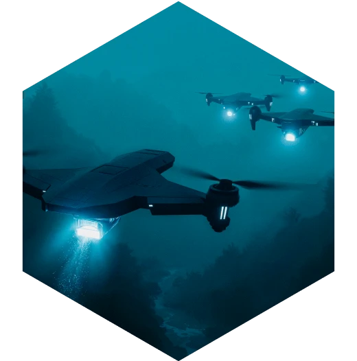Multiple drones flying in a dark landscape at night